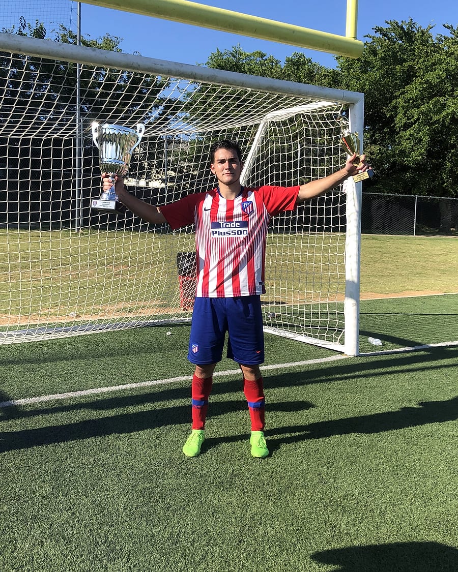 Enmanuel Solano con dos trofeos de campeón en una cancha de Houston, Texas
